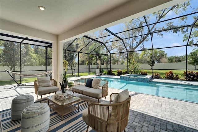 view of swimming pool featuring a pool with connected hot tub, glass enclosure, an outdoor hangout area, a fenced backyard, and a patio area