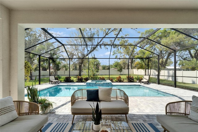 view of pool with glass enclosure, a patio, a fenced backyard, and a pool with connected hot tub