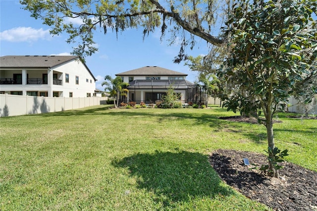 view of yard with glass enclosure and fence