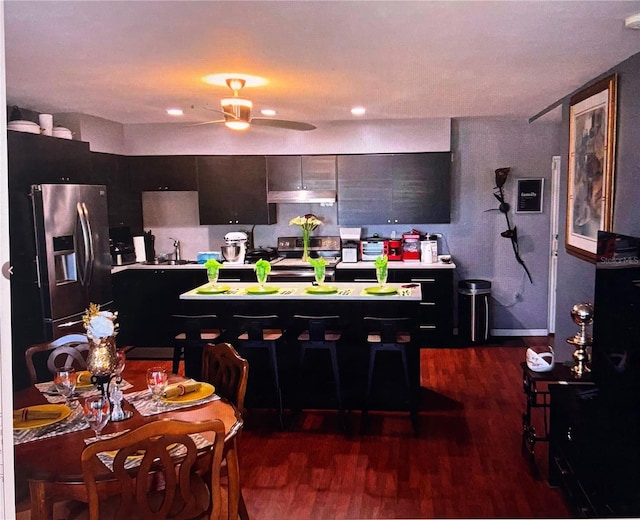 kitchen featuring a sink, dark wood finished floors, stainless steel appliances, light countertops, and dark cabinets