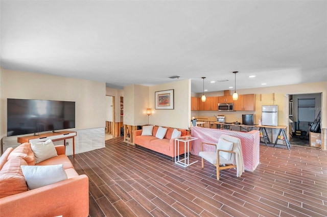 living area with wood tiled floor, visible vents, and recessed lighting