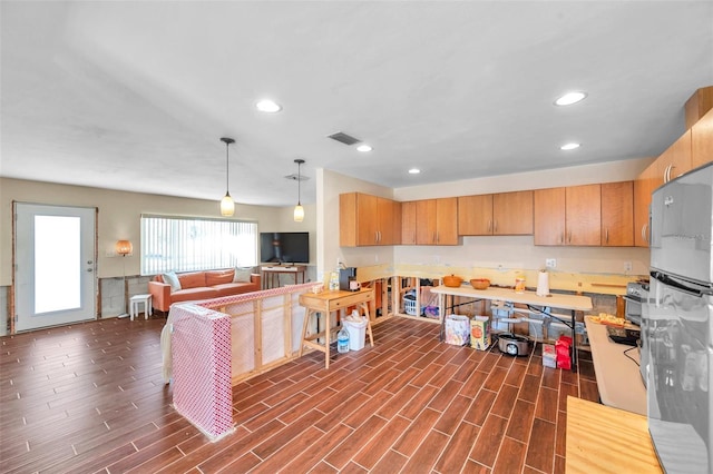 kitchen featuring recessed lighting, visible vents, wood finish floors, and freestanding refrigerator