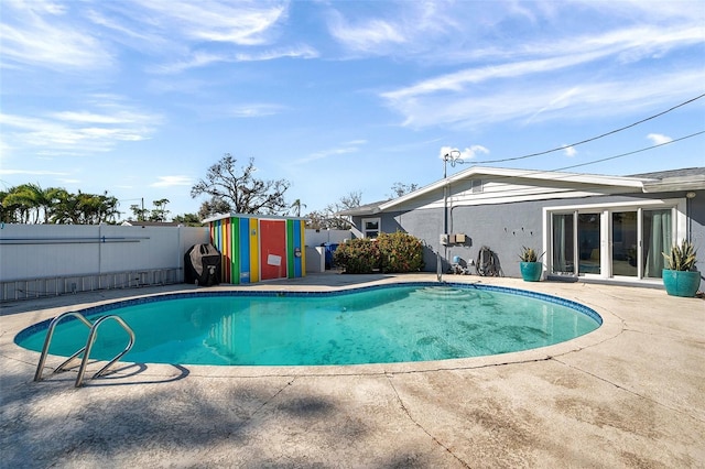 view of pool featuring a fenced backyard, an outbuilding, a fenced in pool, and a patio