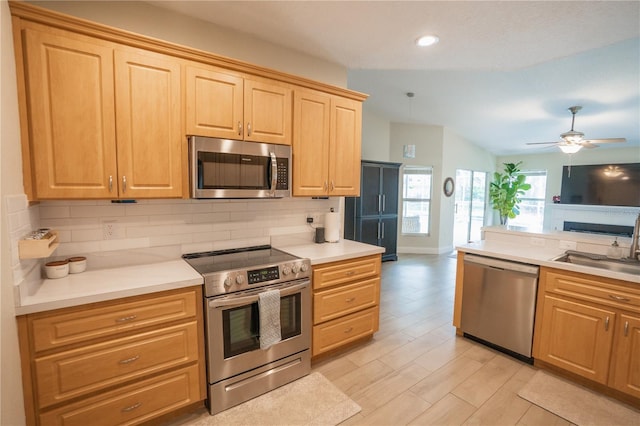 kitchen featuring a sink, decorative backsplash, ceiling fan, light brown cabinetry, and stainless steel appliances