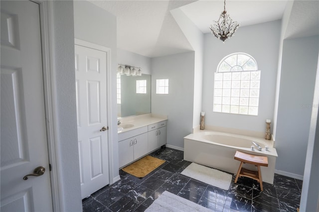 bathroom with a notable chandelier, marble finish floor, baseboards, a bath, and vanity