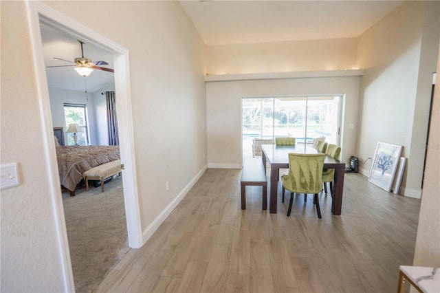 dining room with light wood-style floors, baseboards, and ceiling fan