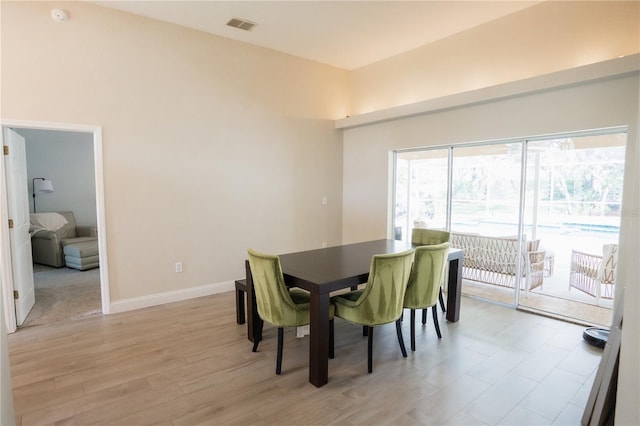 dining area featuring baseboards, visible vents, and light wood-type flooring