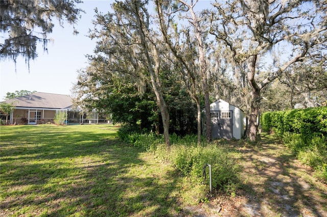 view of yard featuring a lanai, a storage unit, and an outdoor structure