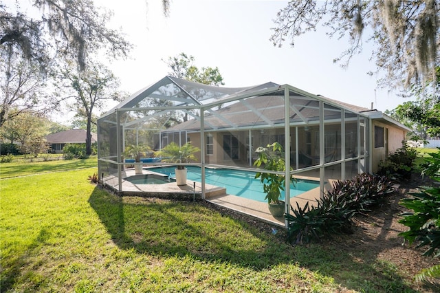 view of swimming pool featuring glass enclosure, a lawn, a patio area, and a pool with connected hot tub