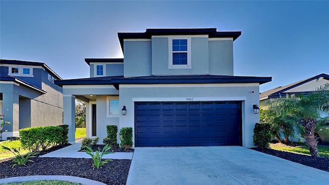 view of front of property with stucco siding, concrete driveway, and an attached garage