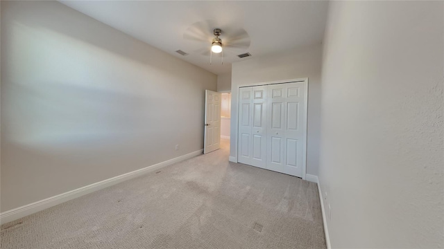 unfurnished bedroom featuring visible vents, baseboards, light colored carpet, and a closet