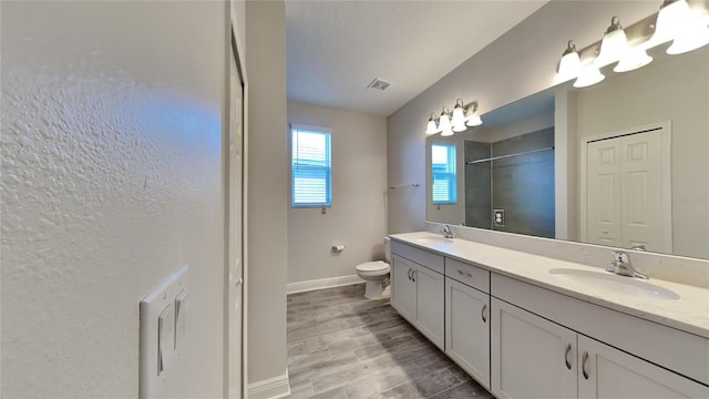 full bathroom featuring double vanity, toilet, wood finished floors, and a sink