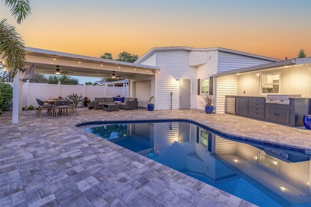 view of pool featuring a ceiling fan, an outdoor hangout area, fence, exterior kitchen, and a patio area