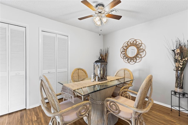 dining area featuring ceiling fan, a textured ceiling, baseboards, and wood finished floors