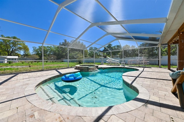 view of swimming pool with a patio area, a pool with connected hot tub, fence, and glass enclosure