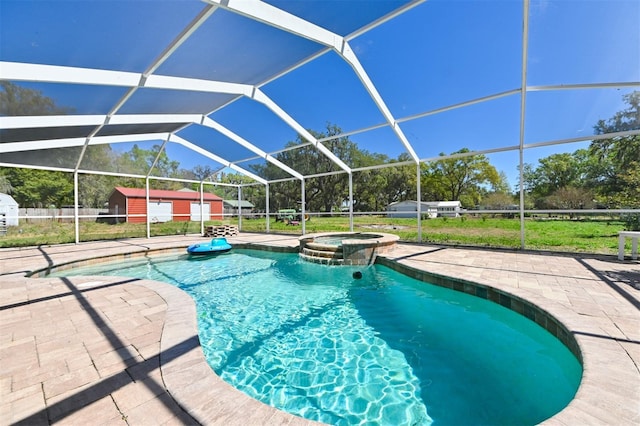 view of swimming pool featuring an outbuilding, a pool with connected hot tub, a patio area, and a lanai