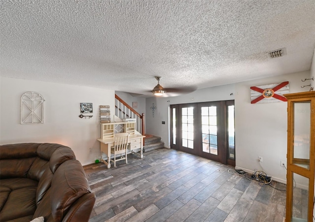 living room with visible vents, ceiling fan, wood finished floors, stairs, and french doors