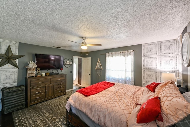 bedroom featuring a ceiling fan, dark colored carpet, and a textured ceiling