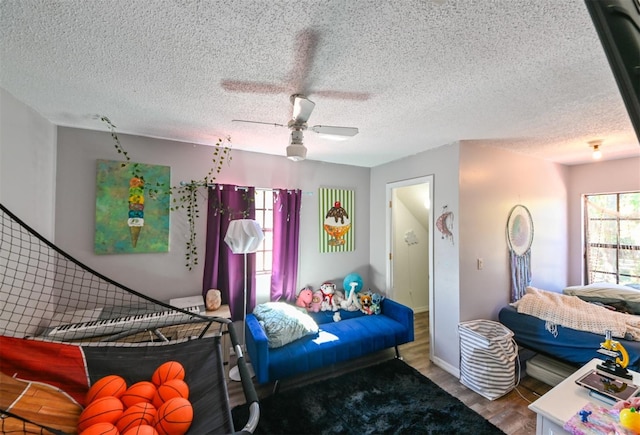 bedroom with baseboards, a textured ceiling, a ceiling fan, and wood finished floors