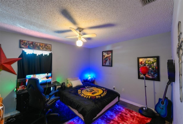 bedroom featuring a textured ceiling, visible vents, a ceiling fan, and baseboards