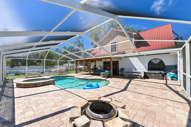 view of swimming pool featuring a pool with connected hot tub, a patio area, a fenced backyard, and glass enclosure