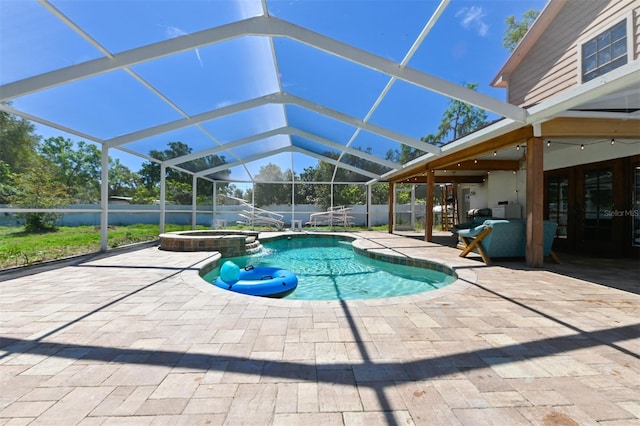 view of pool with a patio, fence, a pool with connected hot tub, and a lanai