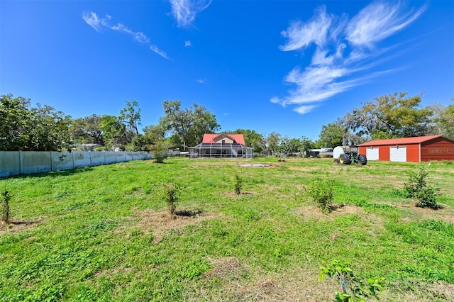 view of yard featuring a garage, driveway, and fence