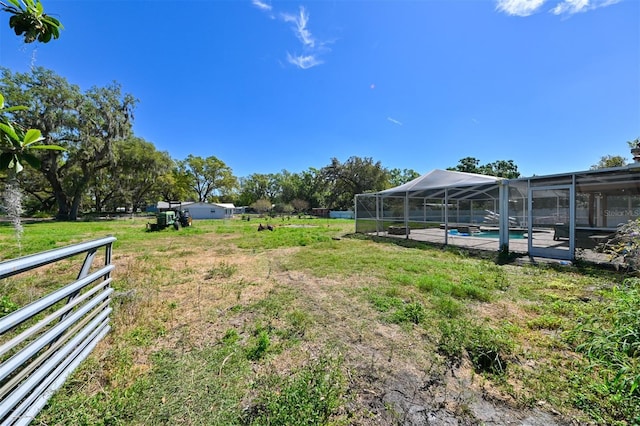 view of yard with glass enclosure and an outdoor pool