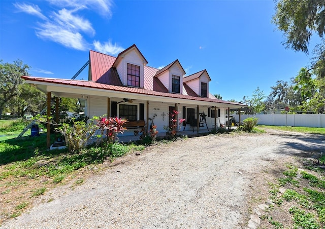 view of front of house with metal roof, a porch, and fence