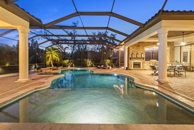 outdoor pool with a patio area and an outdoor stone fireplace