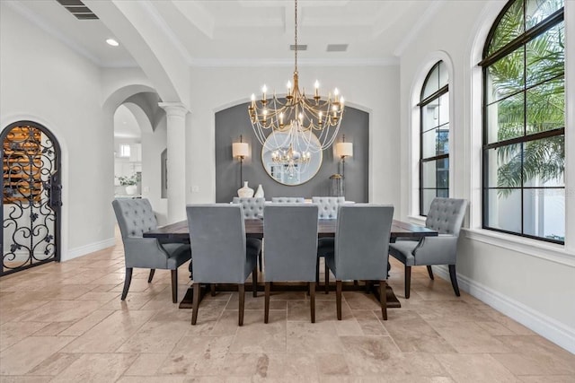 dining space featuring stone tile floors, baseboards, arched walkways, crown molding, and a chandelier