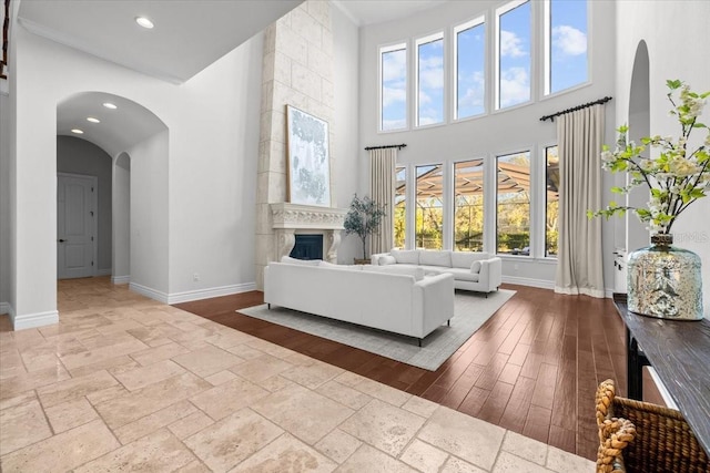 living room with stone tile flooring, recessed lighting, a fireplace, and baseboards