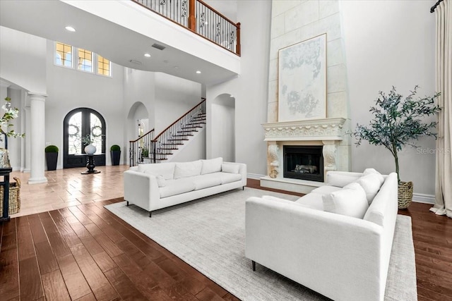 living area featuring a wealth of natural light, arched walkways, and dark wood-style floors