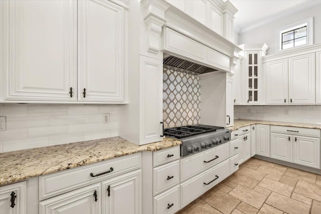 kitchen with white cabinets, premium range hood, crown molding, and stainless steel gas stovetop