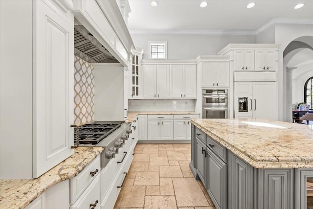 kitchen featuring premium range hood, gray cabinets, stone tile floors, white cabinetry, and stainless steel appliances