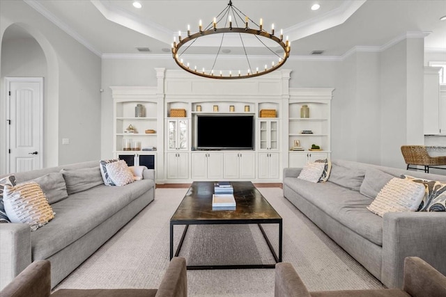 living room featuring arched walkways, visible vents, a raised ceiling, and an inviting chandelier