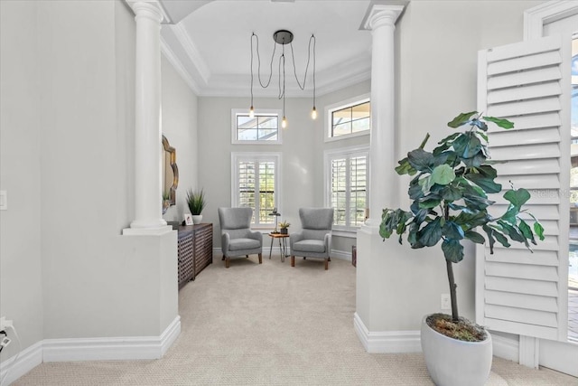 sitting room featuring crown molding, carpet, and ornate columns