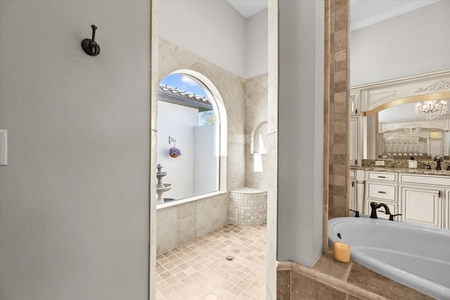 bathroom featuring vanity, a relaxing tiled tub, and tiled shower