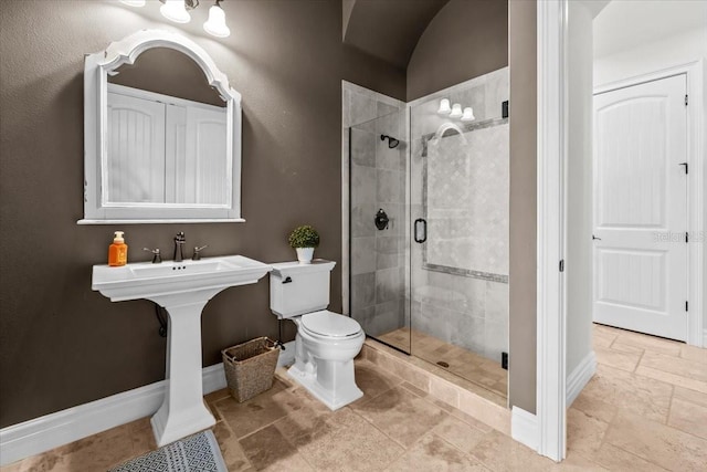 bathroom featuring a shower stall, toilet, and baseboards