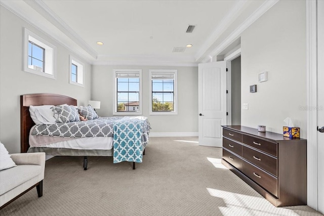 bedroom with visible vents, ornamental molding, a tray ceiling, baseboards, and light colored carpet