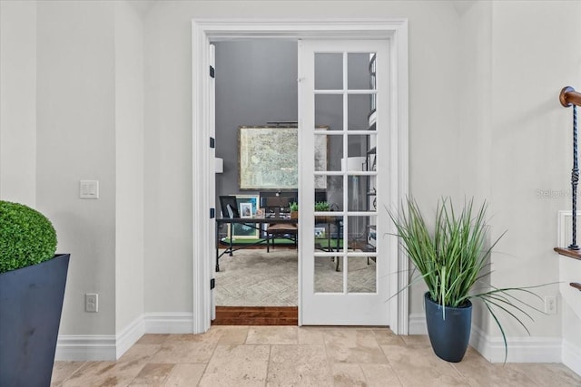 entryway with stone finish flooring and baseboards