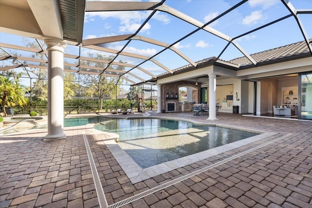 view of pool with a lanai, a pool with connected hot tub, and a patio