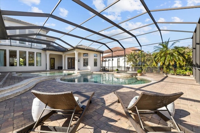 view of swimming pool featuring a lanai, a patio area, and a pool with connected hot tub