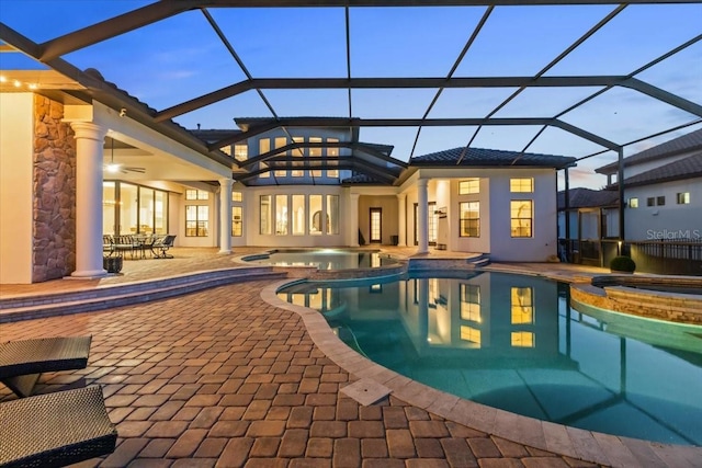 view of swimming pool with a pool with connected hot tub, a lanai, and a patio area