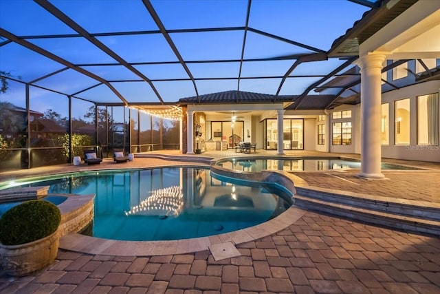 view of swimming pool featuring a pool with connected hot tub, a lanai, and a patio area