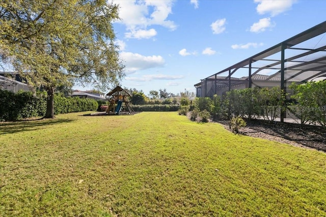 view of yard featuring glass enclosure and a playground