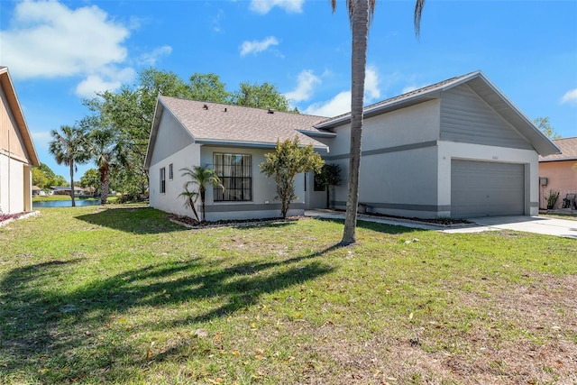 view of front facade with stucco siding, a front yard, concrete driveway, and an attached garage