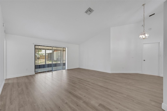 unfurnished living room featuring baseboards, visible vents, high vaulted ceiling, light wood-style floors, and a chandelier