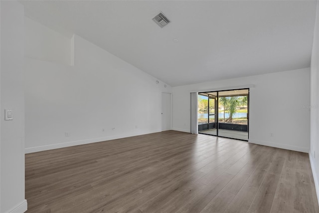 spare room with visible vents, baseboards, high vaulted ceiling, and wood finished floors