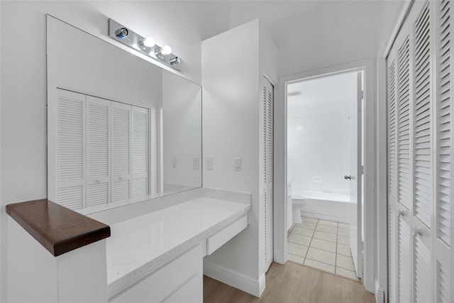 full bath featuring a garden tub, wood finished floors, and a closet